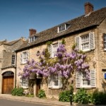 Heritage cottage in conservation area in a village with a blue sky and flowers