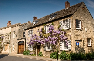 Heritage cottage in conservation area in a village with a blue sky and flowers