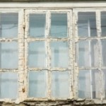 Old flaky timber window with Georgian bars